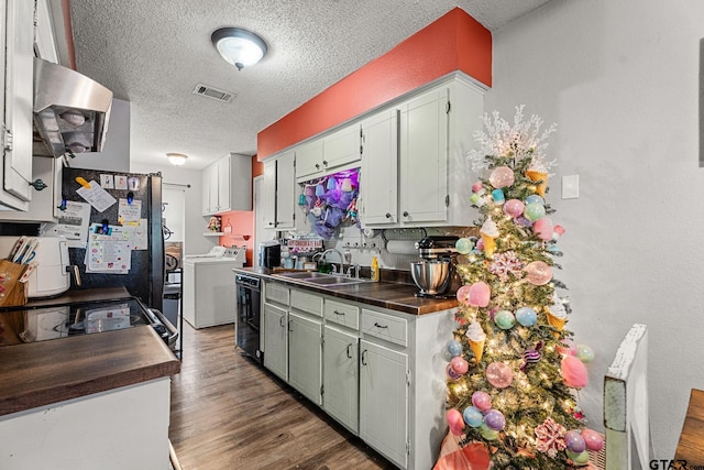 kitchen featuring ventilation hood, sink, dark hardwood / wood-style floors, separate washer and dryer, and a textured ceiling