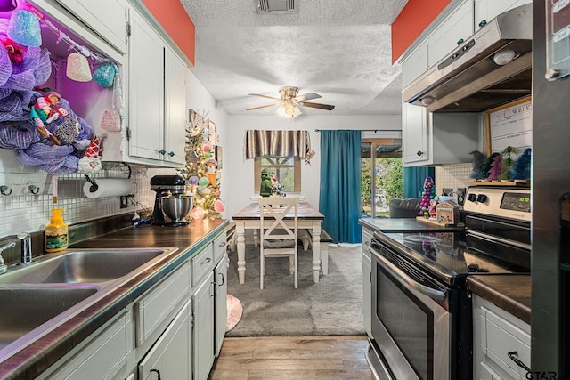 kitchen featuring decorative backsplash, ceiling fan, sink, electric stove, and light hardwood / wood-style flooring