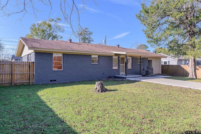 back of property with central AC, a patio area, and a lawn