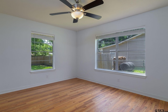 unfurnished room featuring wood-type flooring, ceiling fan, and a healthy amount of sunlight