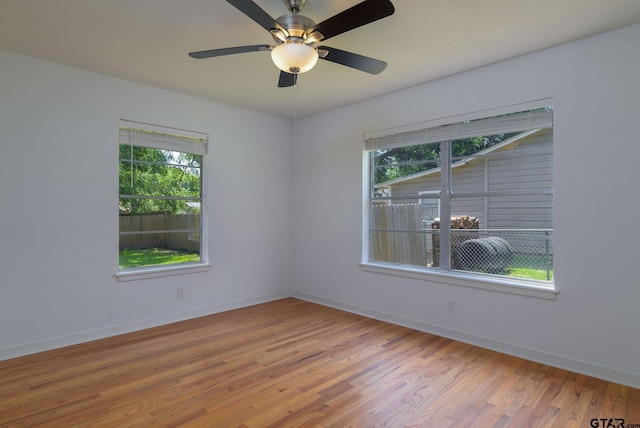 unfurnished room with ceiling fan, hardwood / wood-style floors, and a healthy amount of sunlight