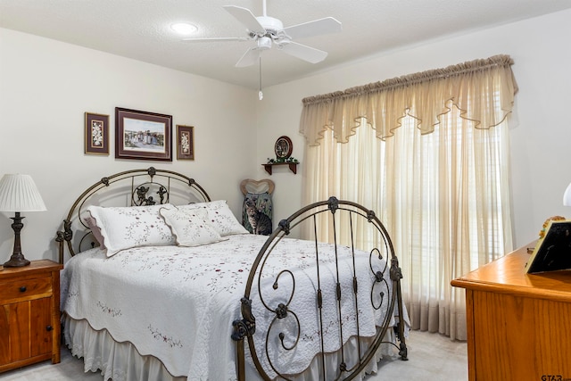 carpeted bedroom with a textured ceiling and ceiling fan