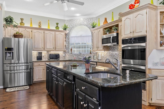 kitchen featuring appliances with stainless steel finishes, sink, an island with sink, and crown molding