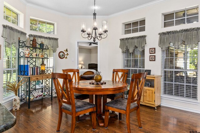 dining space with dark wood-type flooring, ornamental molding, and an inviting chandelier