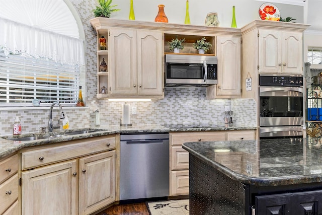 kitchen with dark stone countertops, light brown cabinets, sink, and stainless steel appliances