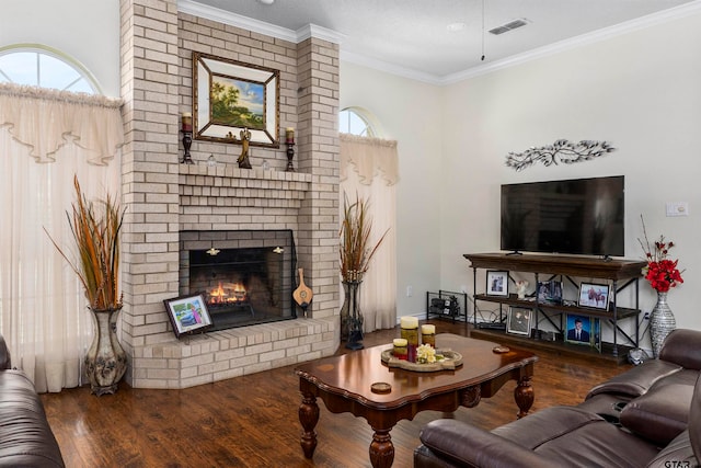 living room with a textured ceiling, crown molding, dark hardwood / wood-style floors, and a brick fireplace