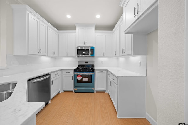 113 Hay Mdw, Winona, TX 75792 - kitchen with stainless steel appliances, light wood-type flooring, backsplash, white cabinetry, and recessed lighting