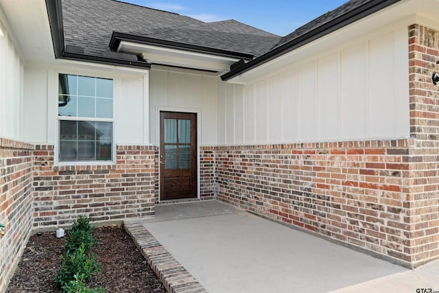 113 Hay Mdw, Winona, TX 75792 - doorway to property featuring brick siding, roof with shingles, and a patio