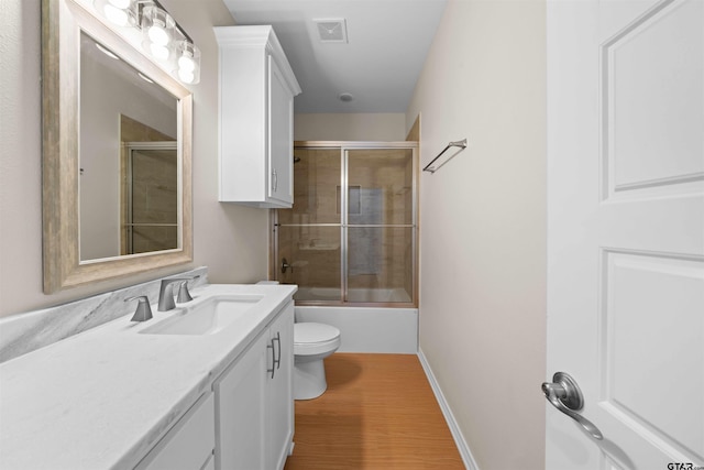 113 Hay Mdw, Winona, TX 75792 - full bathroom with vanity, wood finished floors, toilet, combined bath / shower with glass door, and baseboards