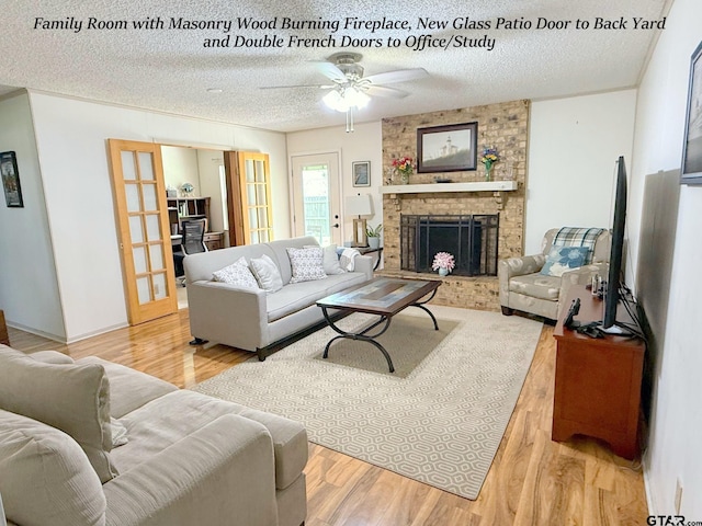 237 Oregon St, Van, TX 75790 - living room with a ceiling fan, a textured ceiling, a brick fireplace, french doors, and wood finished floors