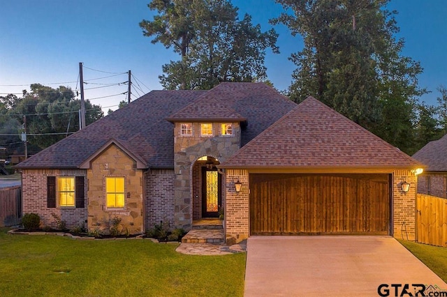 view of front of property featuring a garage and a front lawn