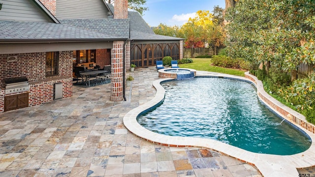 2205 Kingsmill Cir, Tyler, TX 75703 - view of pool featuring a pool with connected hot tub, an outdoor kitchen, a patio area, a grill, and a fenced backyard