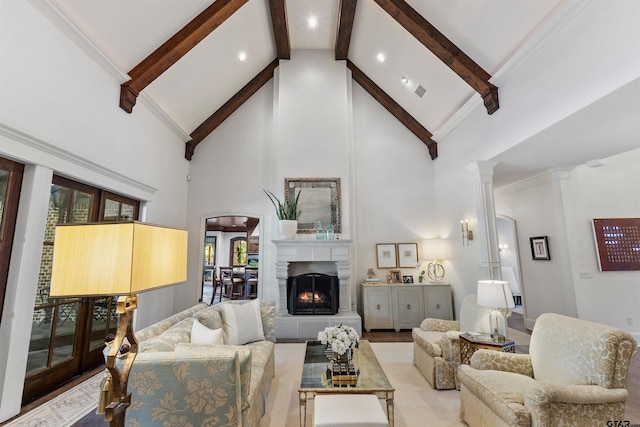 2205 Kingsmill Cir, Tyler, TX 75703 - living room featuring arched walkways, beamed ceiling, ornate columns, a fireplace, and high vaulted ceiling