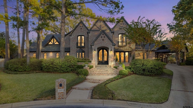 view of front of home featuring concrete driveway, brick siding, and a front yard