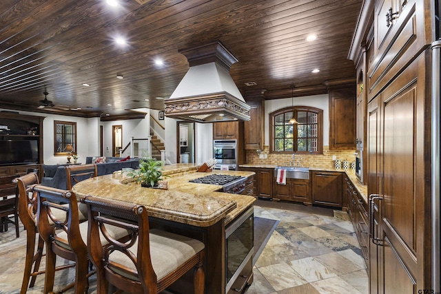 2205 Kingsmill Cir, Tyler, TX 75703 - kitchen with backsplash, wood ceiling, open floor plan, a kitchen island, and built in microwave