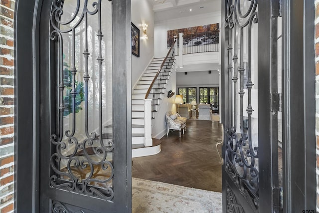 entrance foyer featuring ornamental molding, a high ceiling, stairway, and baseboards