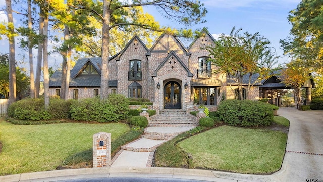2205 Kingsmill Cir, Tyler, TX 75703 - view of front facade with french doors, brick siding, driveway, and a front lawn