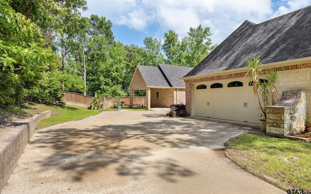 view of front of property featuring a shingled roof, concrete driveway, brick siding, and fence