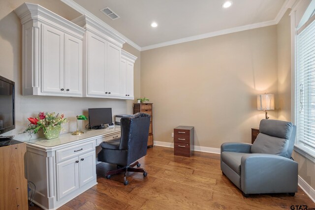 office with baseboards, light wood-style floors, built in study area, plenty of natural light, and crown molding