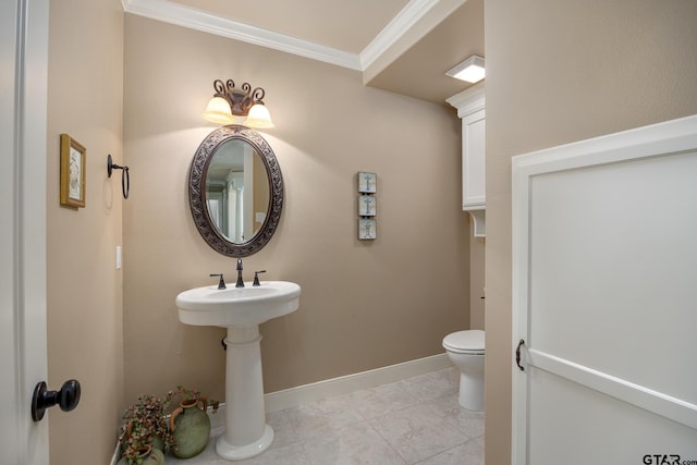 bathroom with crown molding, toilet, and baseboards