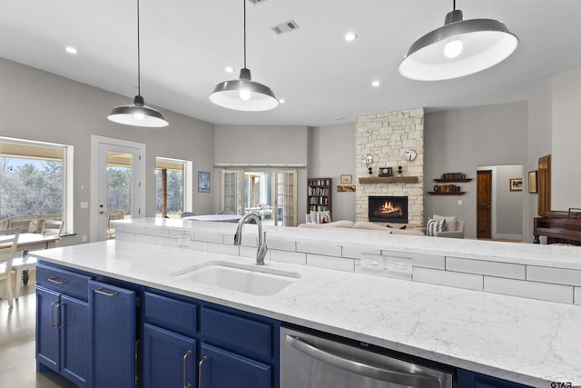 kitchen featuring hanging light fixtures, blue cabinetry, sink, and stainless steel dishwasher