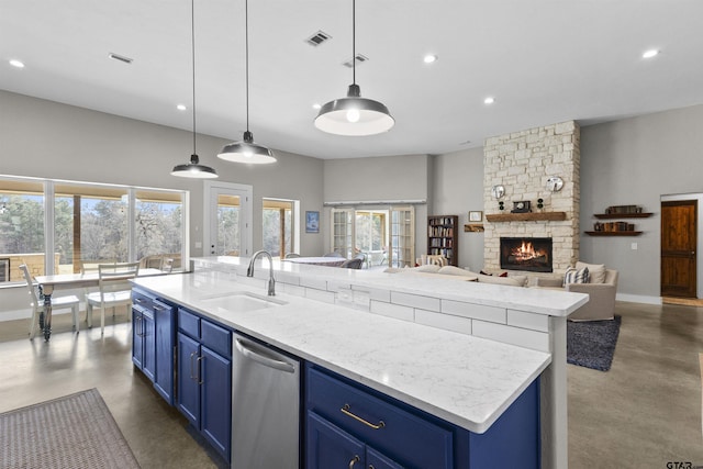 kitchen featuring sink, blue cabinetry, a center island with sink, and pendant lighting