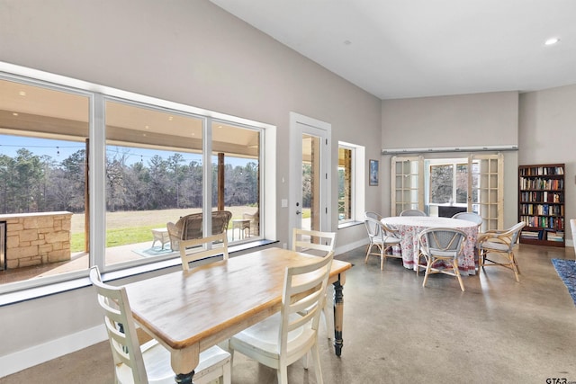 dining area with a wealth of natural light and concrete floors