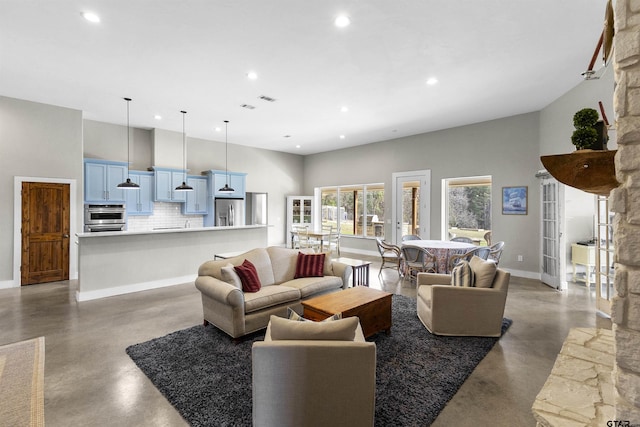 living room with a towering ceiling and concrete floors