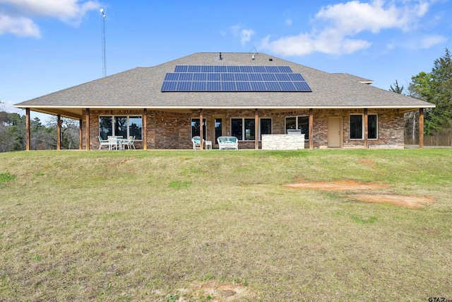 rear view of house with solar panels and a lawn