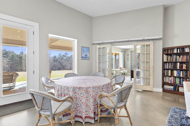 dining area featuring french doors and concrete floors