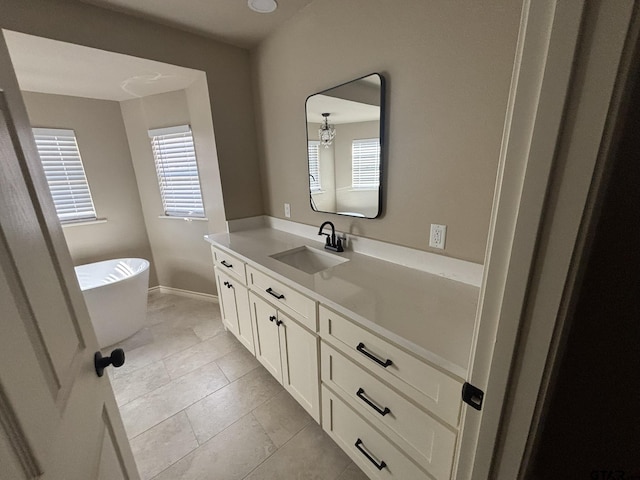 bathroom with tile patterned flooring, vanity, and a tub to relax in