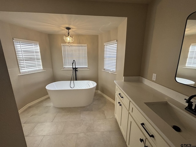 bathroom with vanity, tile patterned flooring, a wealth of natural light, and a bathing tub