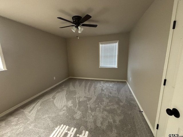 carpeted spare room featuring ceiling fan