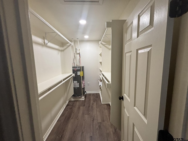 spacious closet with water heater and dark hardwood / wood-style flooring