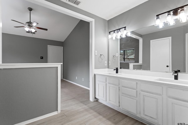 bathroom featuring hardwood / wood-style flooring, ceiling fan, vanity, and lofted ceiling