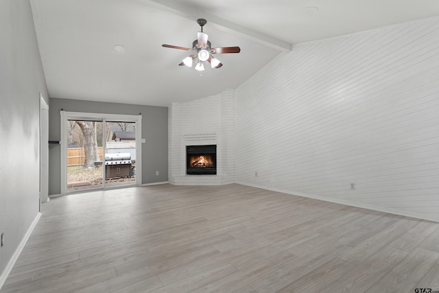 unfurnished living room with ceiling fan, light hardwood / wood-style floors, vaulted ceiling with beams, and a fireplace