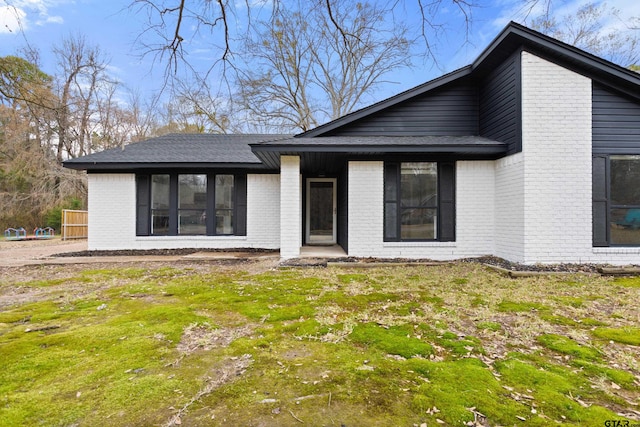 rear view of house featuring a yard