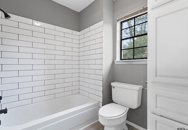 bathroom featuring tiled shower / bath and toilet