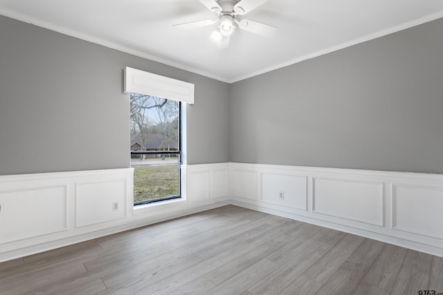 empty room featuring light wood-type flooring, ornamental molding, and ceiling fan