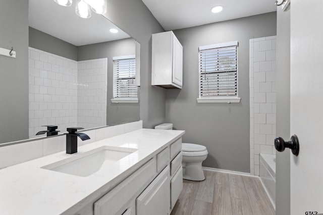 full bathroom featuring toilet, vanity, hardwood / wood-style floors, and tiled shower / bath