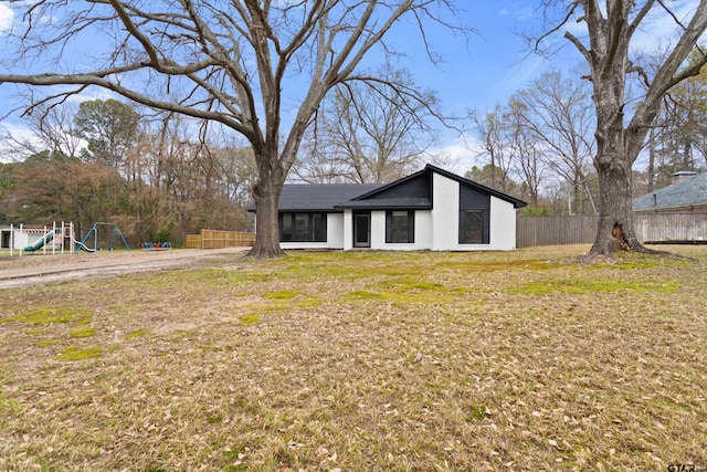 view of front of home featuring a playground and a front yard