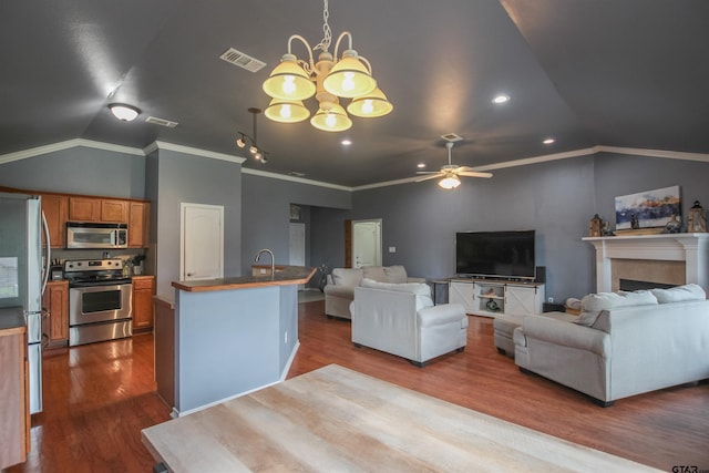 5734 Mustang Trl, Tyler, TX 75707 - living area with lofted ceiling, dark wood-style flooring, a chandelier, ceiling fan, and ornamental molding