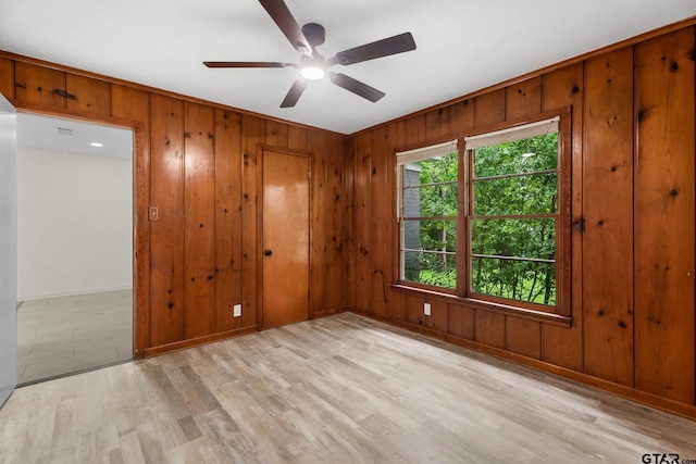 708 E Barbara St, Tyler, TX 75701 - spare room with wooden walls, a ceiling fan, and light wood-style floors