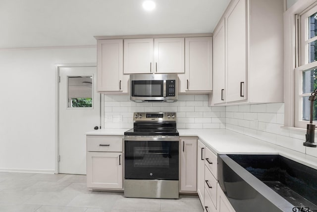 708 E Barbara St, Tyler, TX 75701 - kitchen featuring stainless steel appliances, backsplash, and light countertops
