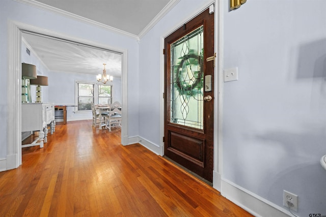 foyer featuring hardwood / wood-style flooring, a chandelier, and crown molding