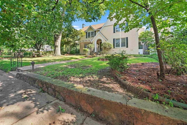 145 Rowland Pl, Tyler, TX 75701 - traditional-style home featuring a front yard, stucco siding, and a chimney