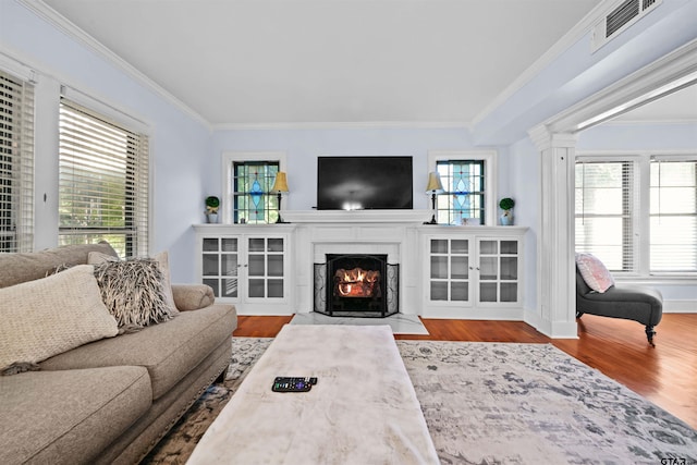 living room with ornamental molding, light hardwood / wood-style floors, and decorative columns