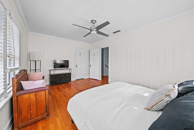 bedroom featuring ornamental molding, hardwood / wood-style flooring, and ceiling fan