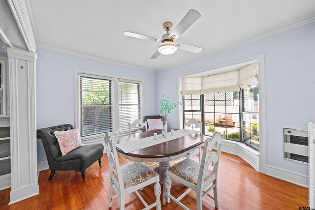 dining room featuring ceiling fan, heating unit, hardwood / wood-style floors, and ornamental molding