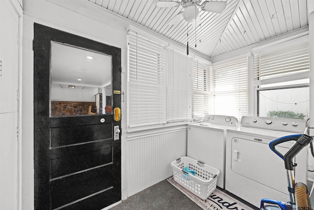 clothes washing area with carpet floors, wood walls, ceiling fan, and washer and dryer